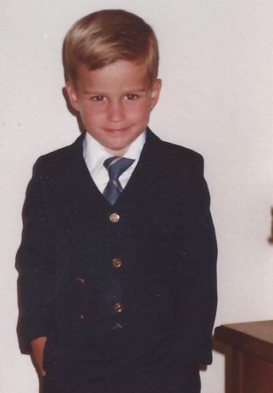 Childhood picture of Jon-Michael Ecker posing for a photoshoot wearing black suit and pant